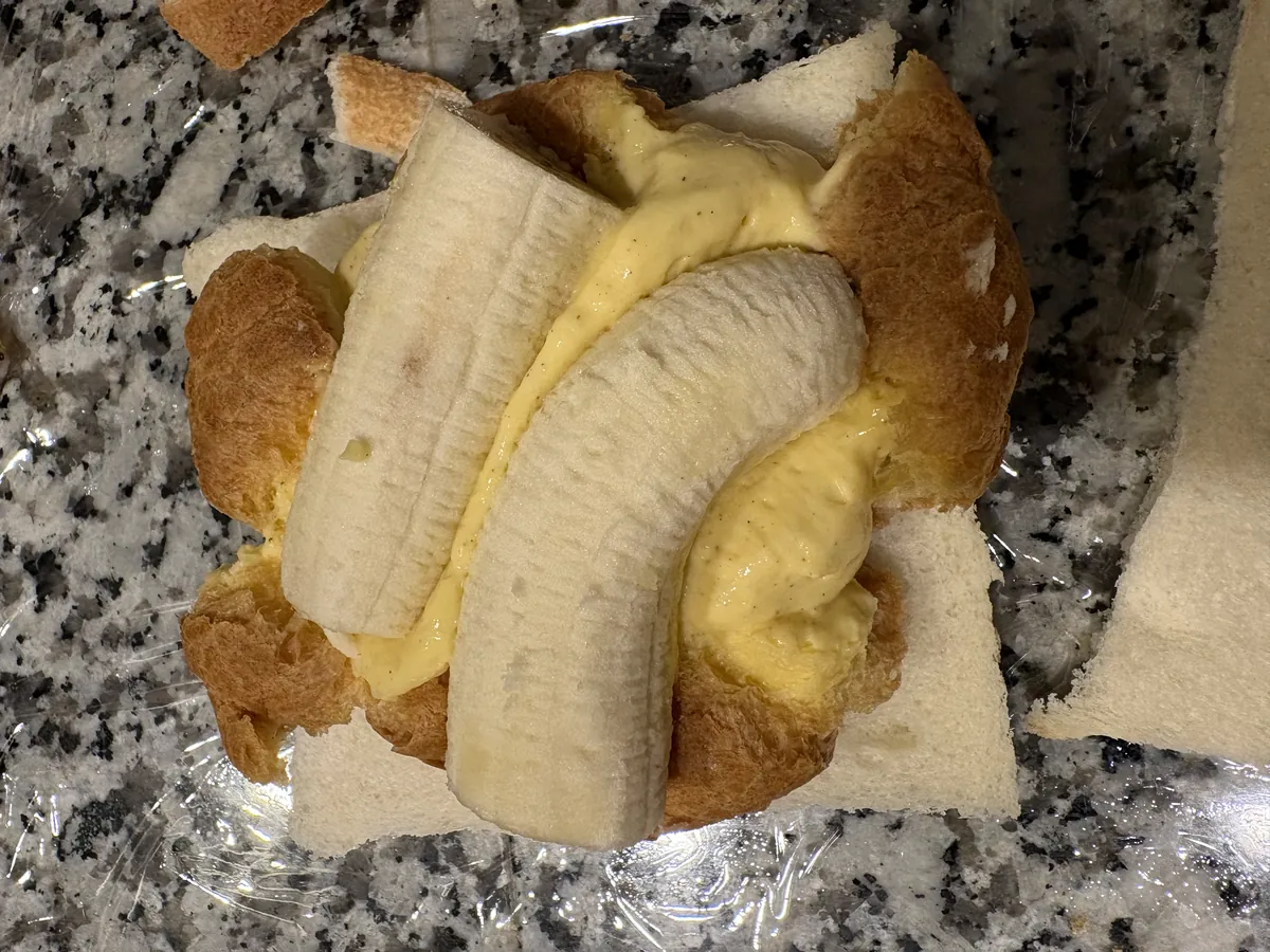 食パンの上に、潰したシュークリームと輪切りのバナナを並べたところ